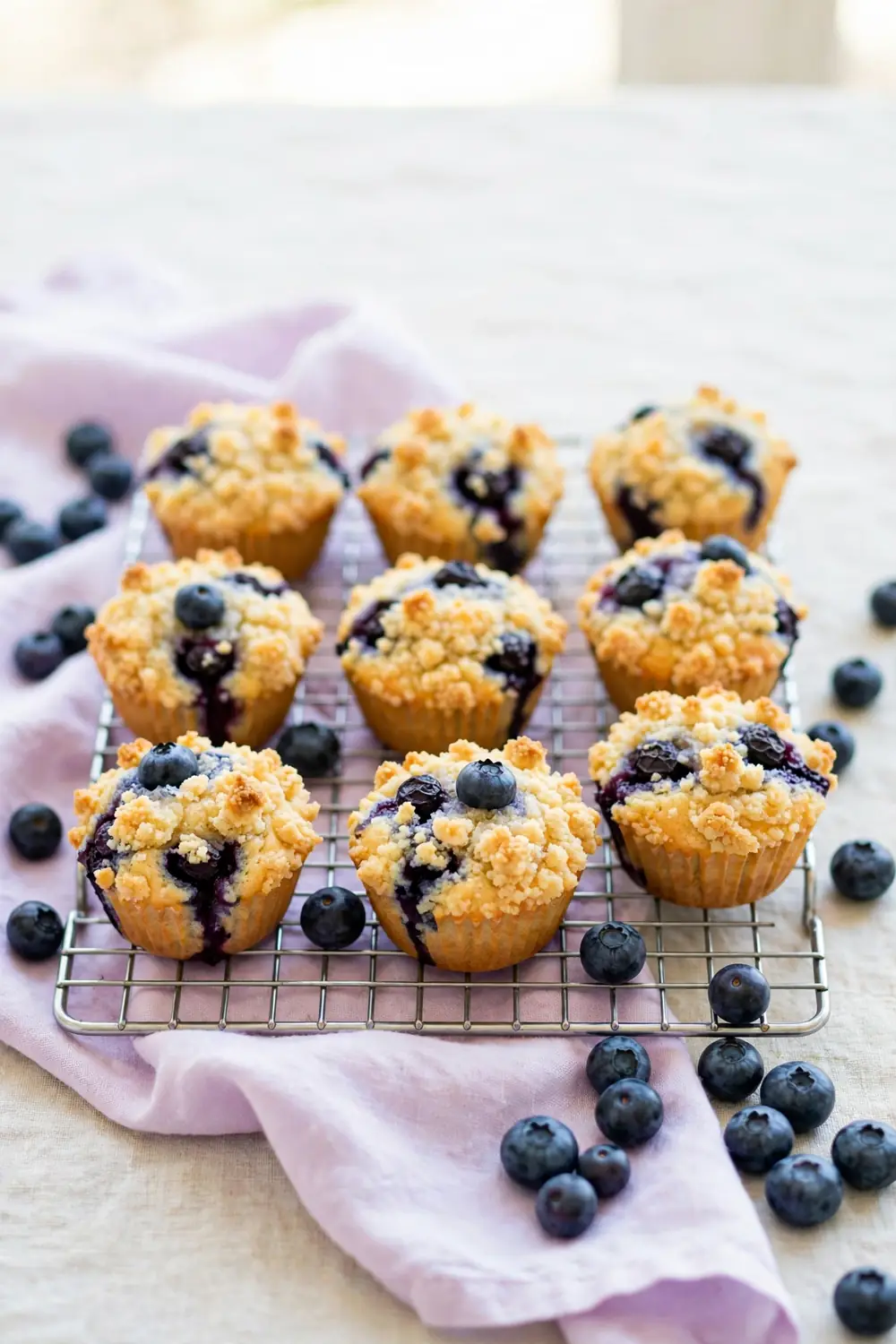 Blueberry crumb cake mini muffin cups on a cooling rack