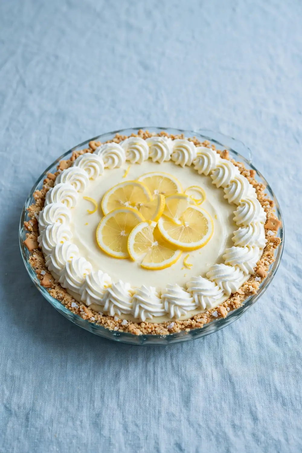 Chilled citrus pie in a glass dish with whipped cream border