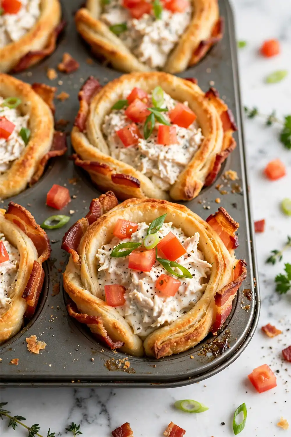 Crispy bacon crescent cups filled with creamy ranch chicken in a muffin tin