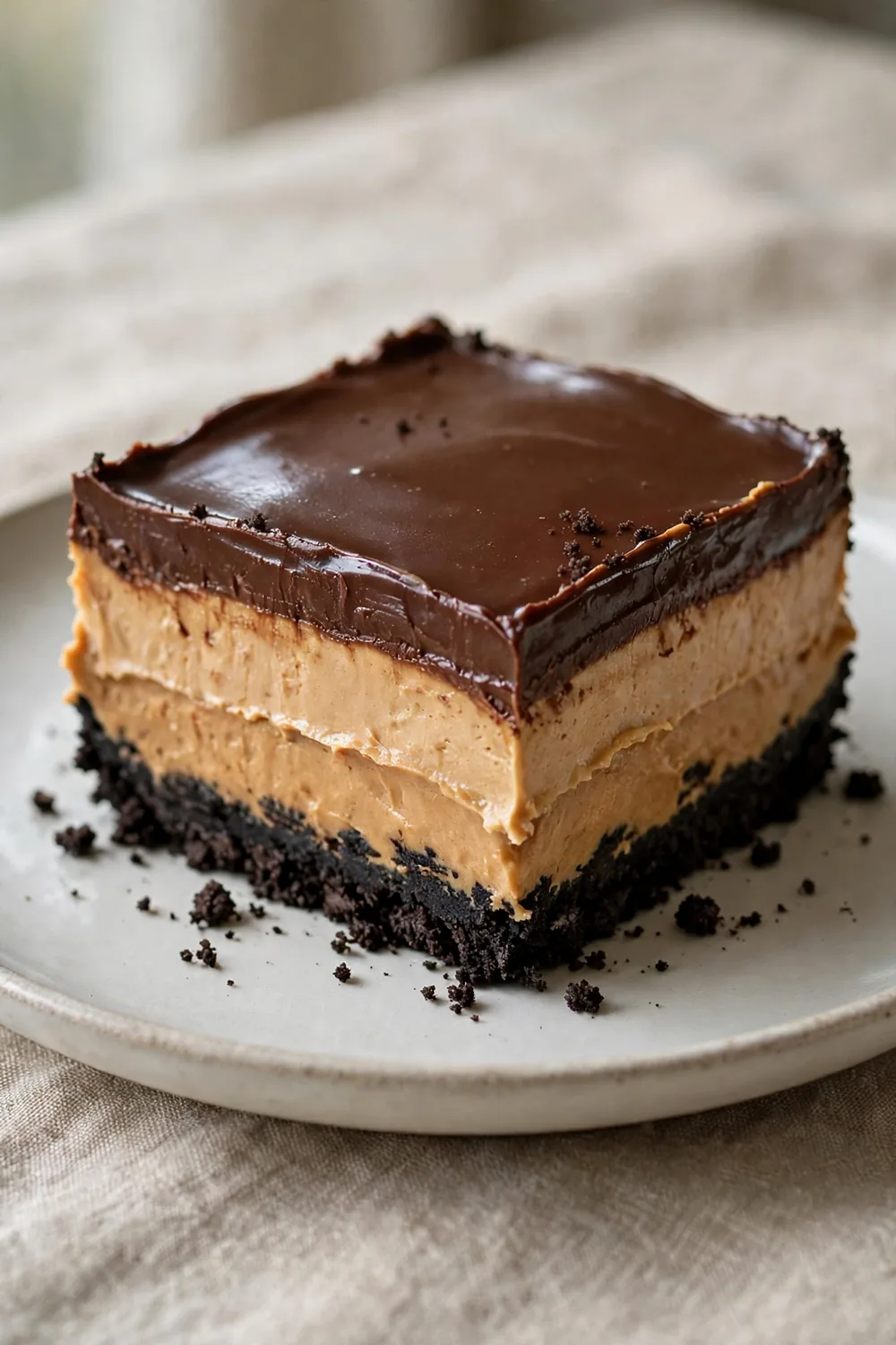 Layered chocolate and peanut butter dessert with Oreo crumb crust