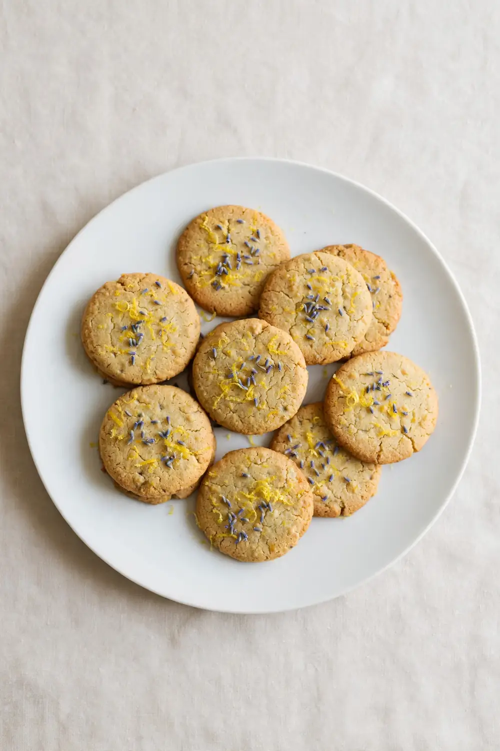 Lemon ricotta cookie rounds with lavender buds and lemon zest
