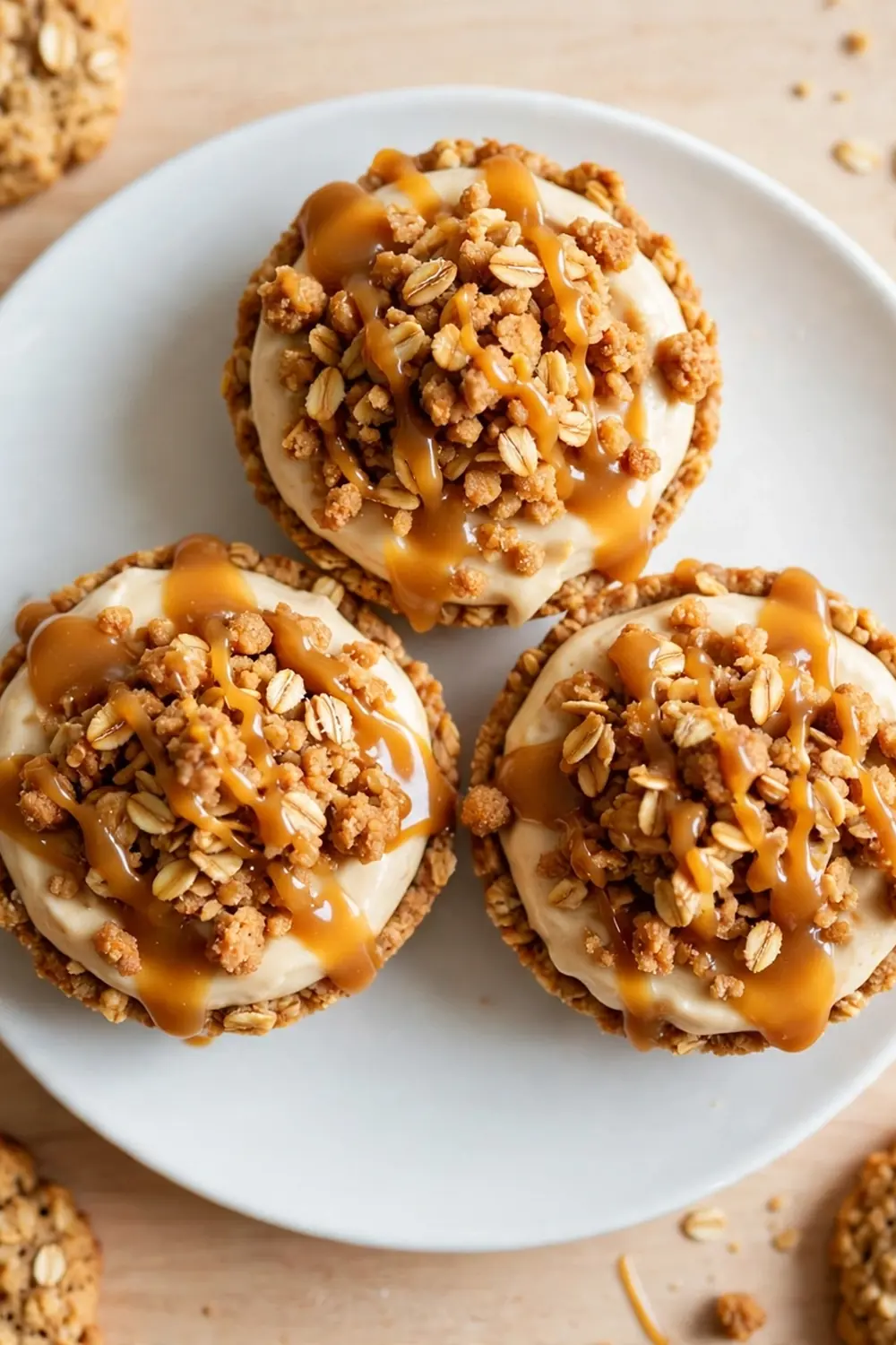 Oatmeal cookie sandwich pie with toasted oat crumble topping and caramel drizzle on a white plate