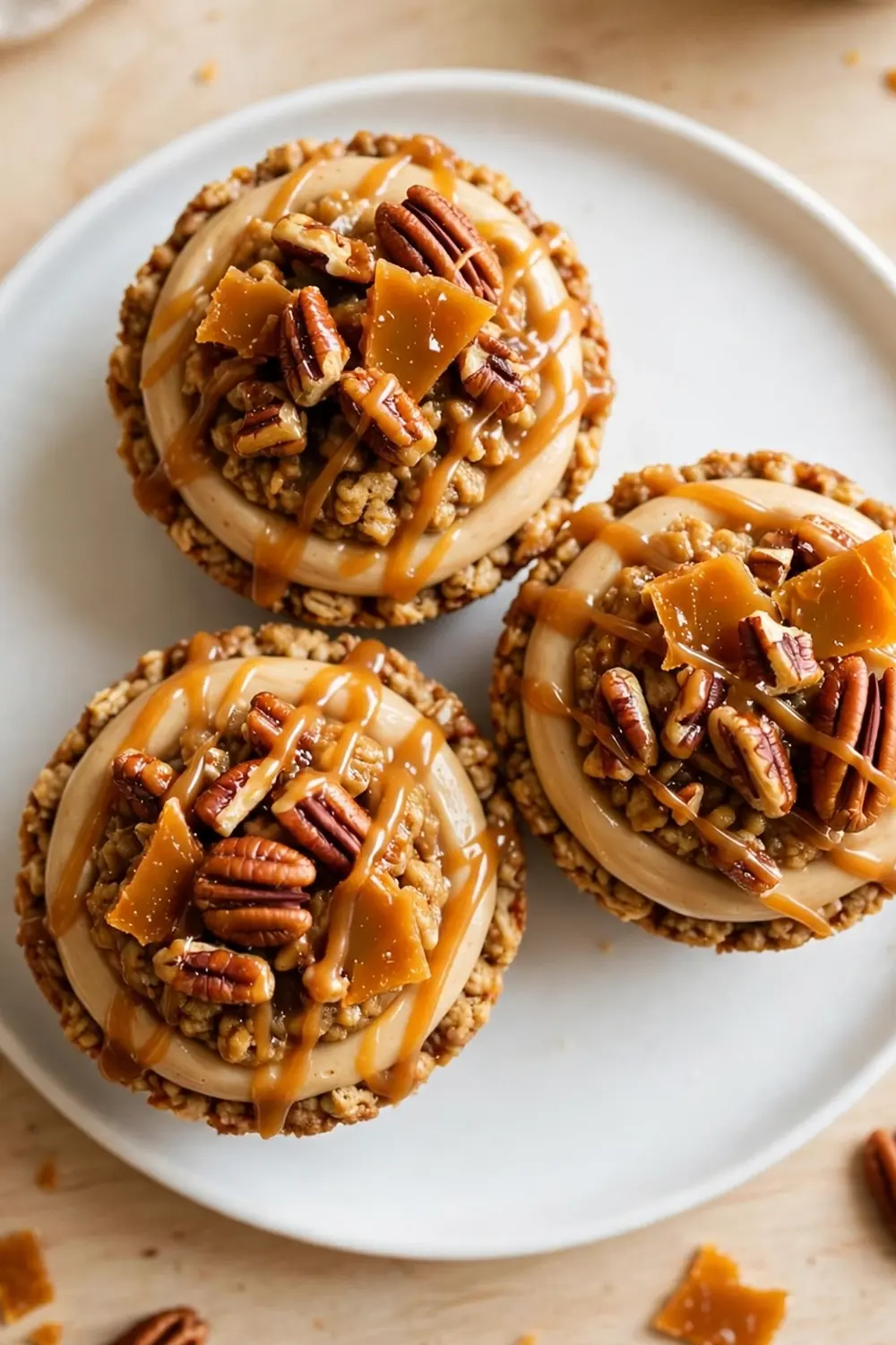 Oatmeal cookie sandwich pie with pecan praline topping and caramel drizzle on a white plate