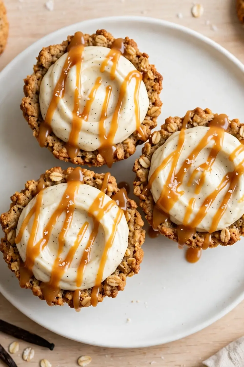 Oatmeal cookie sandwich pie with vanilla bean cream filling showing tiny dark seeds on a white plate