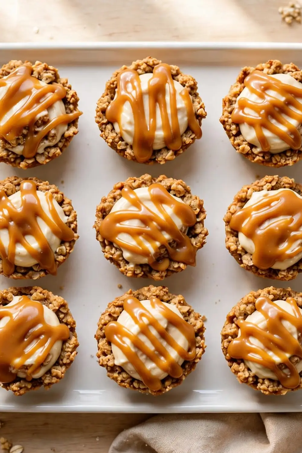 Mini oatmeal cookie sandwich pies on a party tray with caramel drizzle and toppings