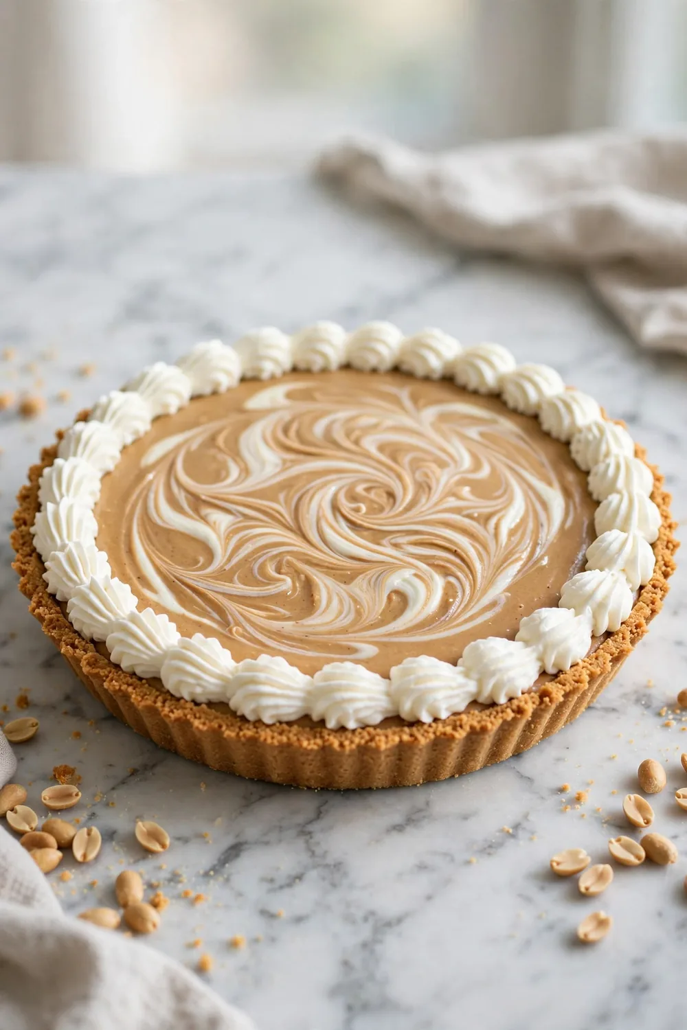 Peanut butter dessert with cream cheese marble swirls and whipped cream edge