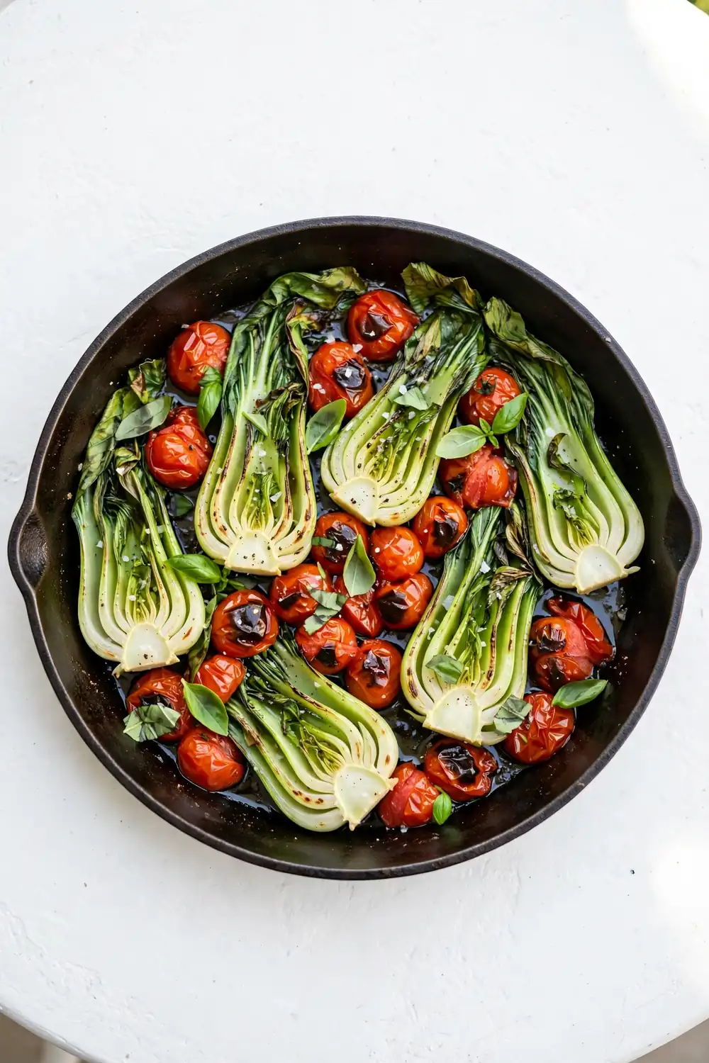 Bok choy with tomatoes and basil in a skillet
