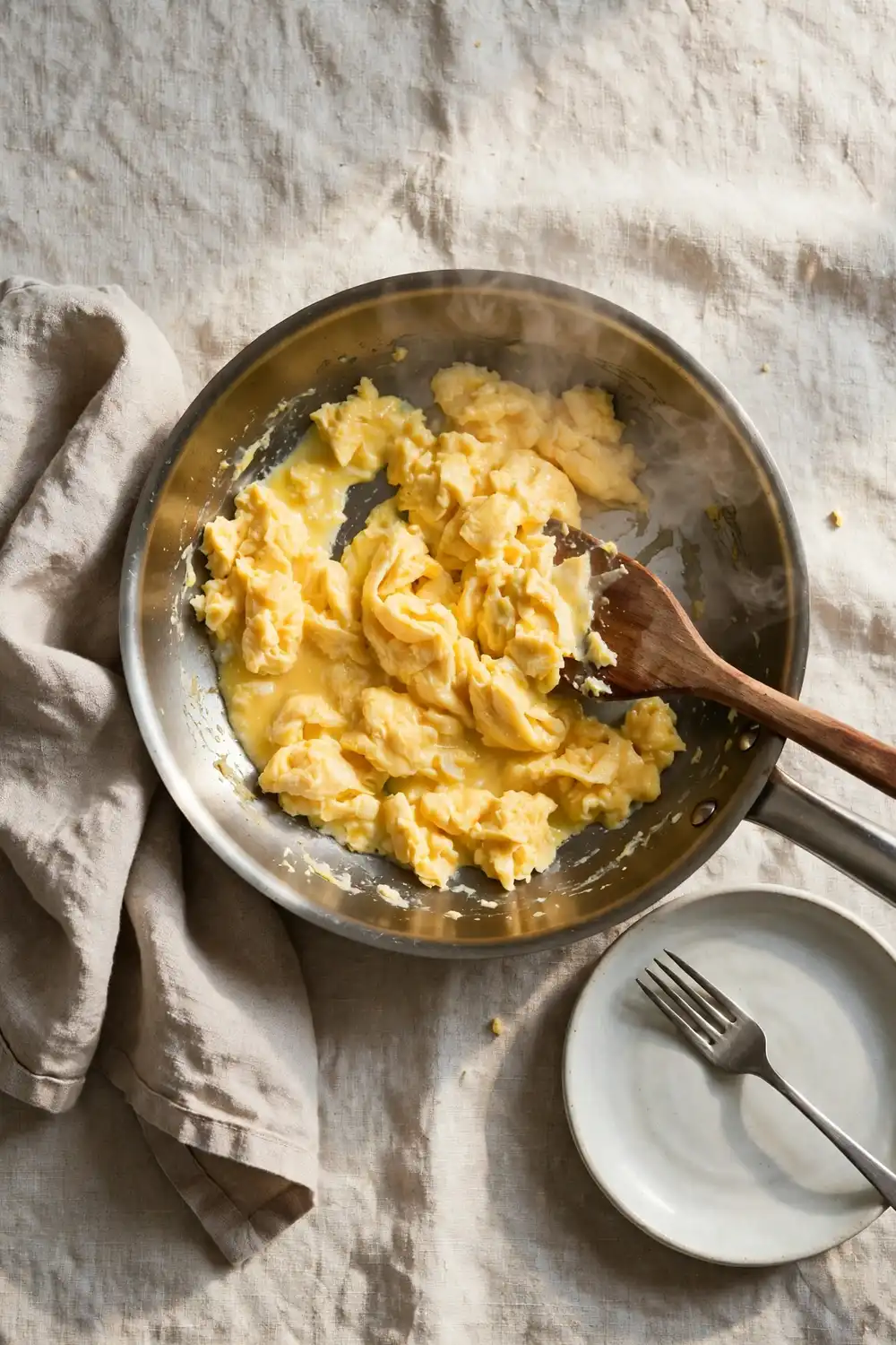 Scrambled eggs stirred gently in a pan